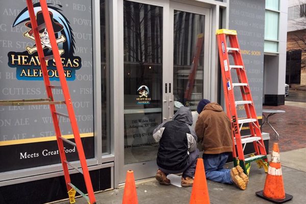 Workers affix signage to the door of the soon-to-open Heavy Seas Alehouse in Rosslyn