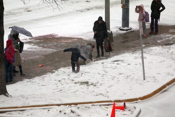 Children start a snowball fight while waiting for a school bus in Pentagon City