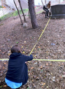 Morgane Murawiec, foreground, and the class peer mentor Kristen Eyler measure distances between headstones for a survey of the cemetery site (photo courtesy Marymount University)