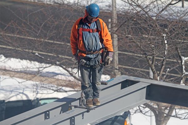Construction worker stands on a beam
