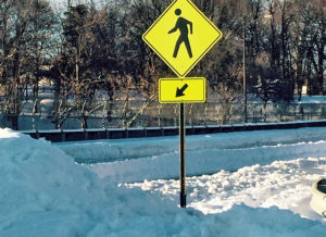 Pedestrian walk sign next to a large snow bank (photo courtesy Dennis W.)