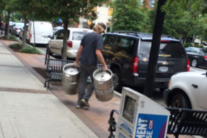 A man carries kegs away from the now-closed Hard Times Cafe in Clarendon